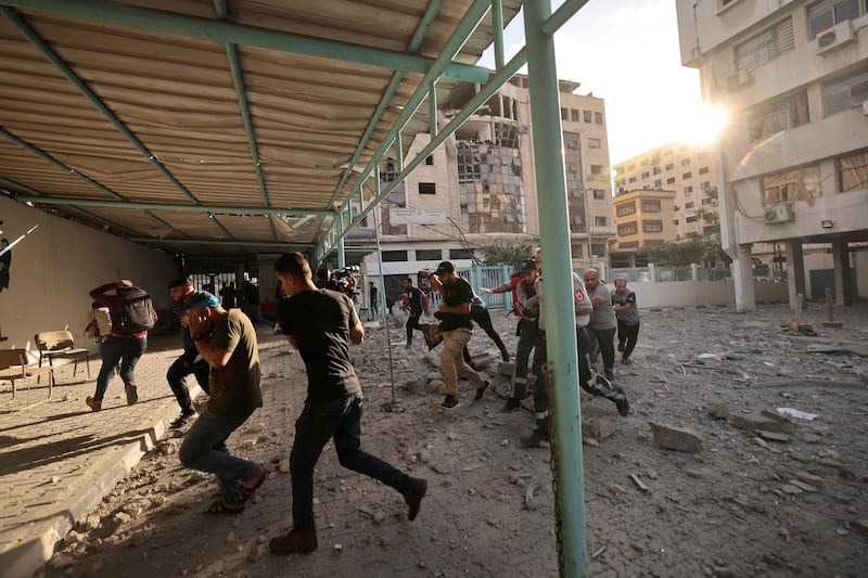 Palestinians run amid Israeli air strikes on Gaza city. AFP