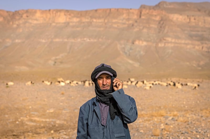 An Amazigh man poses for a picture next to a herd of sheep near the village of Amellagou. Water for livestock is hard to find and the harsh climate threatens his way of life.