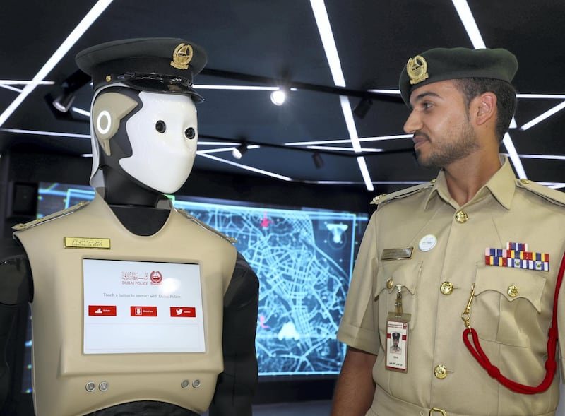 Dubai, United Arab Emirates - October 9th, 2017: Standalone. Bader Abbas Jaafar Hassan with the police robot at Dubai police stand at 37th GITEX technology week. Monday, October 9th, 2017 at World Trade Centre, Dubai. 