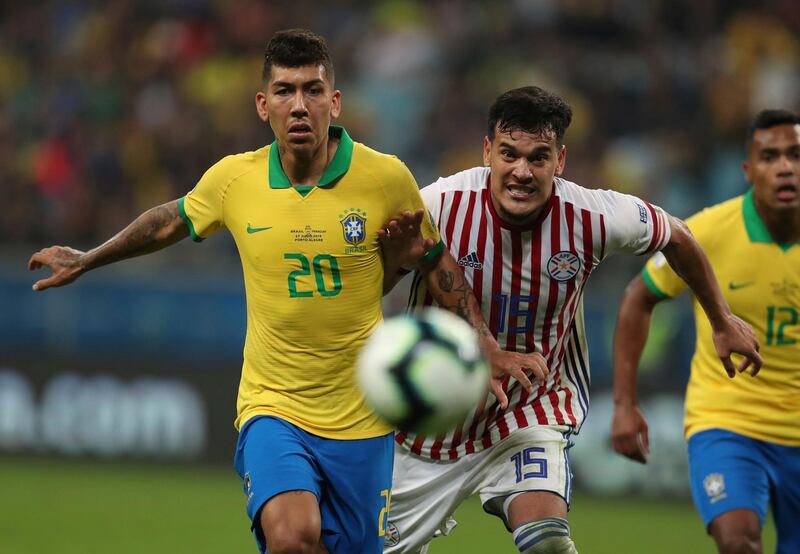 Firmino and Paraguay's Gustavo Gomez eye the ball. AP Photo