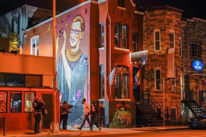 People gather under a mural of Ruth Bader Ginsburg in the U Street neighbourhood in Washington after the announcement of her death. AP Photo
