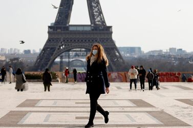 A woman walks past the Eiffel tower at the Trocadero in Paris. Output in France contracted 9.2 per cent last year. Reuters