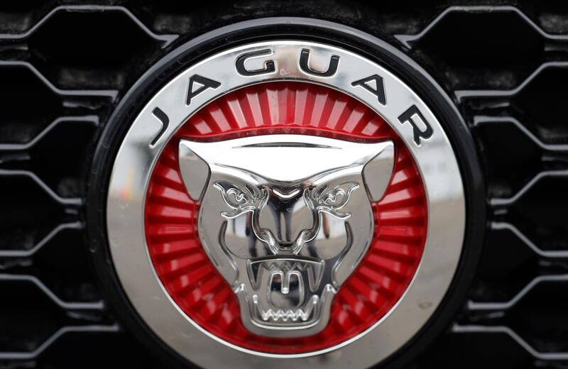 FILE - In this file photo dated Sunday, April 26, 2020, the Jaguar company logo is shown on the grille of an unsold 2020 F-Pace sports-utility vehicle at a Jaguar dealership in Littleton, USA.  The British luxury car brand Jaguar Land Rover said Thursday April 22, 2021, it's suspending production at two U.K. factories, becoming the latest automaker to fall victim to a global shortage of microchips.(AP Photo/David Zalubowski, FILE)