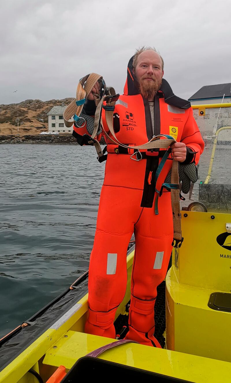 Fisherman Joergen Ree Wiig holds the whale harness after it was removed from a beluga whale off the northern Norwegian coast.  AP