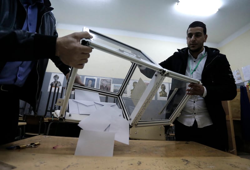Polling station workers empty a ballot box in a polling station in Algiers. Algerians — without a leader since April — voted for a new president or boycotted and held street protests against the elections decried by a massive pro-democracy movement that forced former leader Abdelaziz Bouteflika to resign. AP