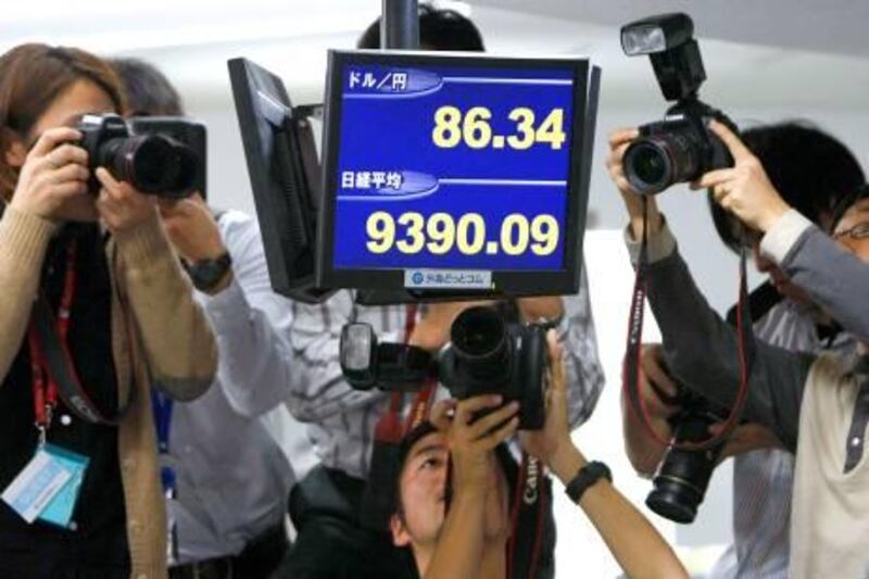 Photographers take pictures of electronic boards showing the Japanese yen's exchange rate against the U.S. dollar (top) and the Nikkei share average at a trading room in Tokyo November 26, 2009. The dollar fell to its lowest in 14 years against the yen on Thursday, touching 86.52 yen on trading platform EBS and triggering sell orders that also helped send it to a fresh 15-month low on the dollar index.     REUTERS/Toru Hanai (JAPAN BUSINESS) *** Local Caption ***  TOK501_MARKETS-FORE_1126_11.JPG