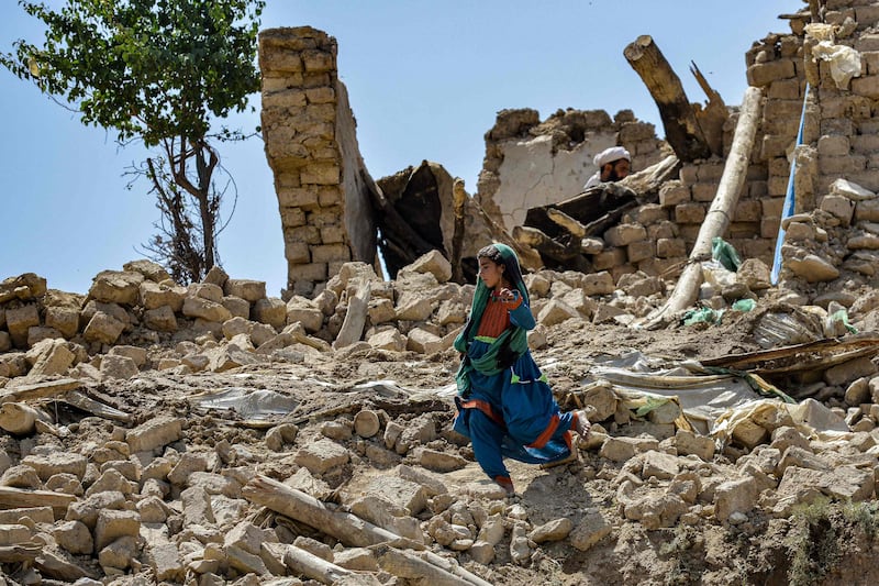 A child walks amidst the ruins of damaged houses after an earthquake struck Bernal district in Paktika province. AFP