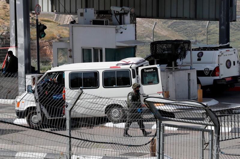 EDITORS NOTE: Graphic content / An Israeli border guard walks past the vehicle of a Palestinian man who reportedly carried out an attack against israeli forces and was subsequently shot dead at a checkpoint in the occupied West Bank between the village of Abu Dis and the town of Bethlehem, on April 22, 2020. An unidentified attacker was shot dead after he tried to run down Israeli police at a West Bank checkpoint and then to stab an officer with a pair of scissors, police told AFP. / AFP / Ahmad GHARABLI
