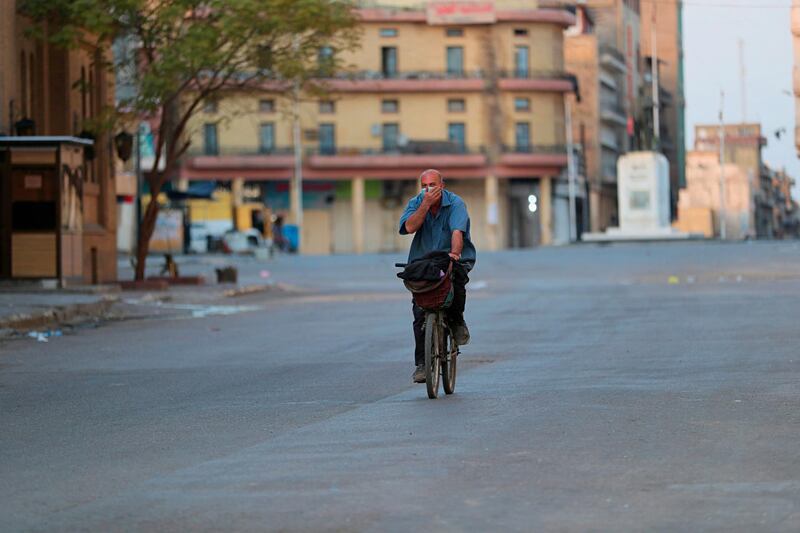 A man rides on his bicycle in an empty street in Baghdad, Iraq. AP