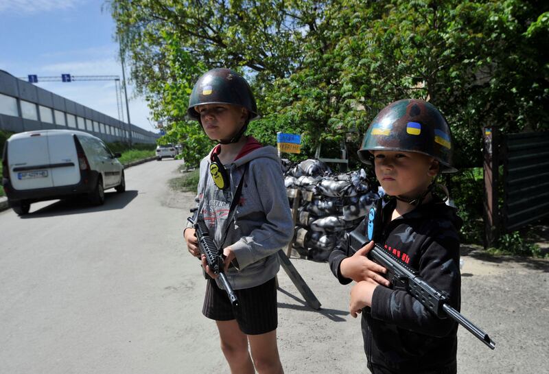 Ukrainian children play war games at a "checkpoint" they set up in Stoyanka, near Kyiv. AFP