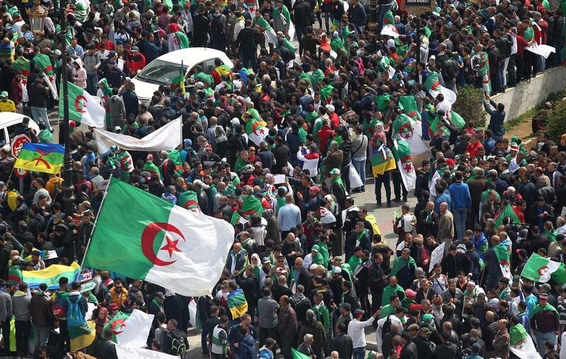 Algerian protesters wave national flags as they take part in an anti-government demonstration in front of La Grande Poste (main post office) in the centre of the capital Algiers on April 12, 2019.  Algerian protesters gathered for the first Friday protests since the announcement of presidential elections to succeed ousted leader Abdelaziz Bouteflika fearing a ploy by the ruling system to stay in power. / AFP / -
