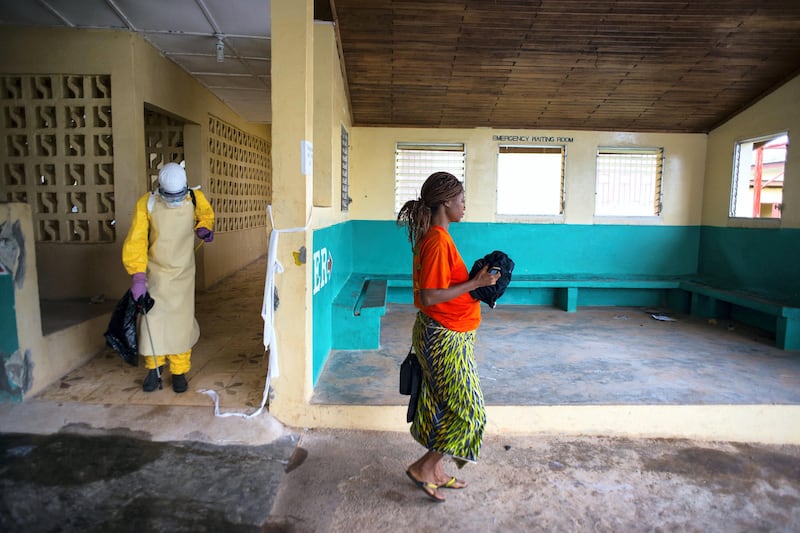 BONG COUNTY, LIBERIA-SEPTEMBER 17:  Josephine Flomo, a pregnant patient  at Phebe Hospital, who has been in isolation at the hospital under observation for ebola walks to a waiting ambulance (a pickup truck) to be taken to the Bong County Ebola Treatment Unit, on Wednesday September 17, 2014. The newly opened 50 bed unit is managed by International Medical Corp, and was built by Save the Children. On its second day of operation to it has 3 new patients; one patient died Monday night. (Photo by Michel du Cille/The Washington Post via Getty Images)