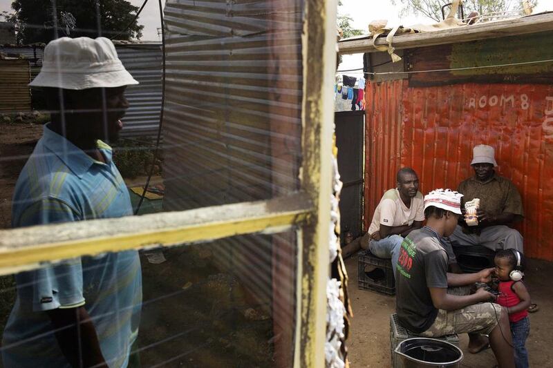 Striking miners idle in the backyard of a shack in Marikana. An entry-level Lonmin worker earns 5,713 rand basic salary a month, but extra allowances and benefits push the package to 9,790 rand. Marco Longari / AFP