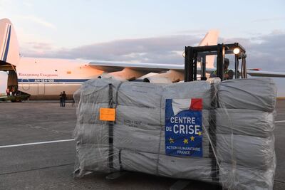 A forklift moves humanitarian supplies to be loaded onto Russian military officer stands by as an Antonov An-124 Ruslan - Widebody at the former Chateauroux-Deols Marcel Dassault Airport in central France on July 20, 2018.  France and Russia are jointly delivering humanitarian aid to the former Syrian rebel enclave of Eastern Ghouta, the French Presidency said in a statement with Russia on July 20. A Russian cargo plane arrived late in Chateauroux to load 50 tons of medical equipment and essential goods provided by France, said an AFP videographer at the scene, to be transported to the former rebel area which was recaptured by Syrian troops this Spring.
 / AFP / Alain JOCARD

