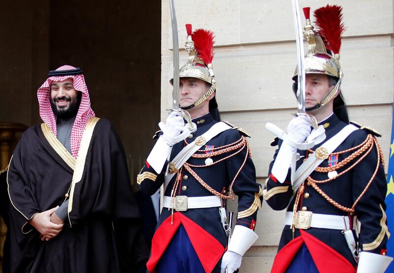 Saudi Arabia's Crown Prince Mohammed bin Salman smiles while Republican Guards salute as he arrives at the French Prime Minister Residence in Paris. Francois Mori / AP Photo