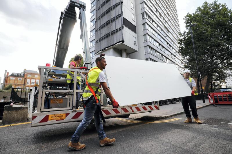 Workers remove panels of external cladding from the facade of Braithwaite House in London, on July 3, 2017, in the wake of the Grenfell Tower fire.
Communities Secretary Sajid Javid announced in the Commons, that all 181 tested samples of cladding had failed safety tests. / AFP PHOTO / Tolga AKMEN