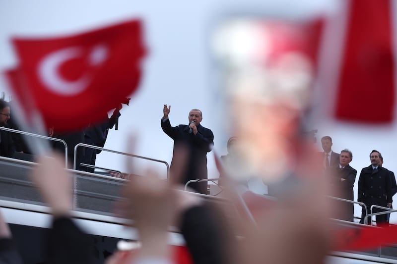 Mr Erdogan speaks to Turkish flag-waving supporters. EPA