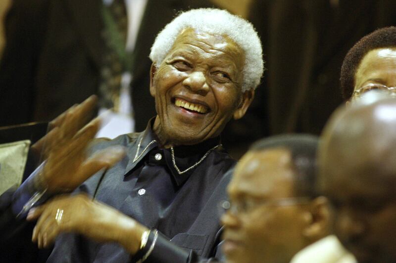 Former South African president Nelson Mandela's, (L) laughs beside his wife Graca Machel (R) from the parliament gallery in Cape Town on February 11, 2010 during a celebration for the 20th year of the icon's freedom from apartheid prison.  Lawmakers cheered and sang "Nelson Mandela, there is none like you" as the 91-year-old former president took his seat in the chamber, accompanied by his wife Graca Machel, smiling and waving in response. AFP PHOTO/SCHALK VAN ZUYDAM *** Local Caption ***  831809-01-08.jpg