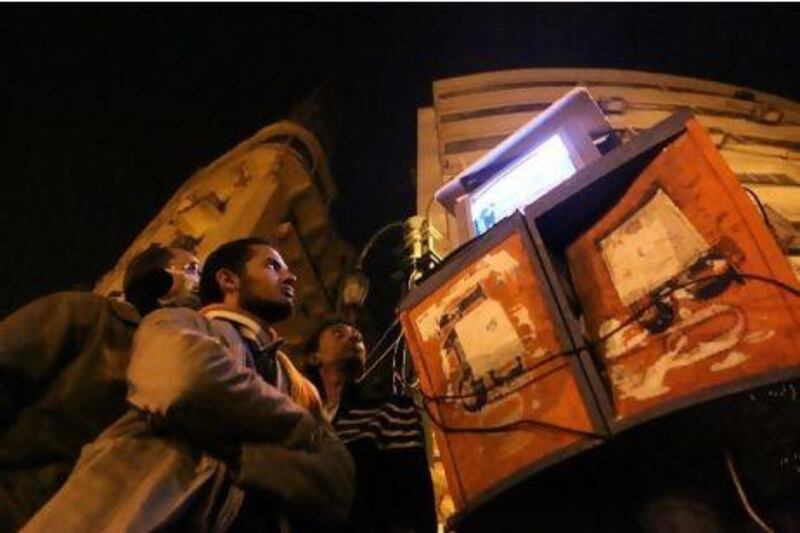 Egyptians watching Al Jazeera on a set placed on top of public telephone booths in Cairo's Tahrir Square, during the demonstrations earlier this year calling for the removal of President Hosni Mubarak's regime. Khaled Desouki / AFP Photo
