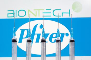 Syringes placed in front of BioNtech and Pfizer logos. The UK and Bahrain are the first two countries to grant emergency use authorisation for the Pfizer-BioNTech Covid-19 vaccine. Reuters