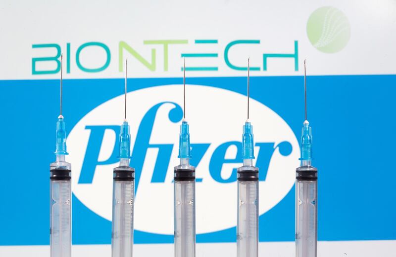 FILE PHOTO: Syringes are seen in front of displayed Biontech and Pfizer logos in this illustration taken November 10, 2020. REUTERS/Dado Ruvic/File Photo