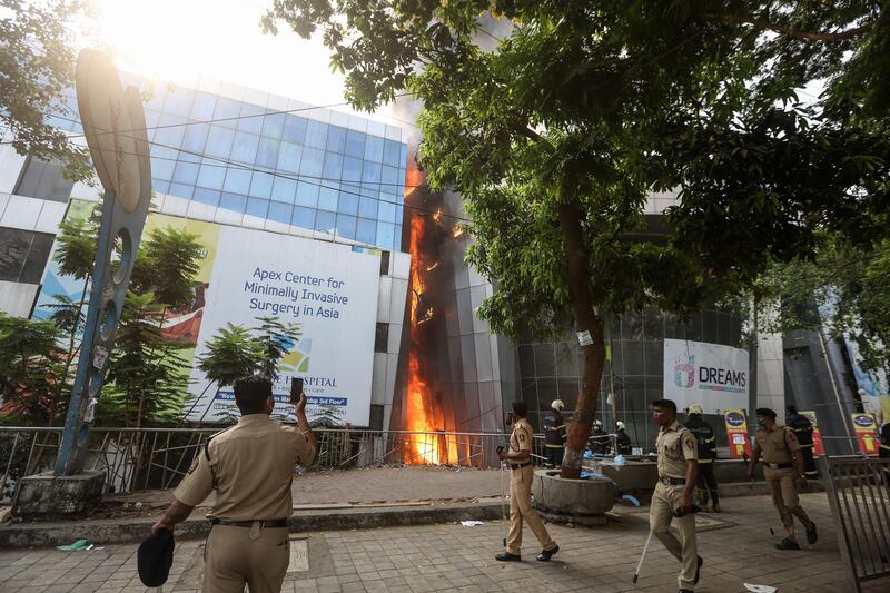 Police gather at the scene of a fire at a Covid-19 hospital inside a mall in Mumbai. EPA