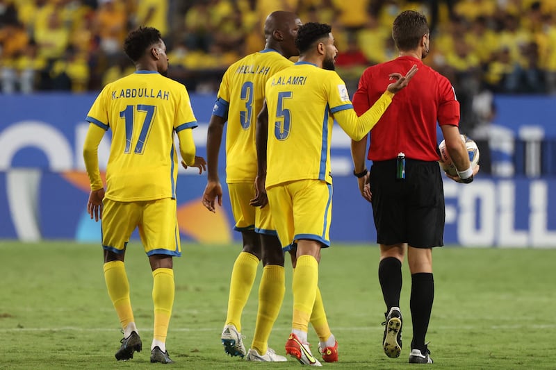 Al Nassr players argue with the referee Chris Beath. AFP