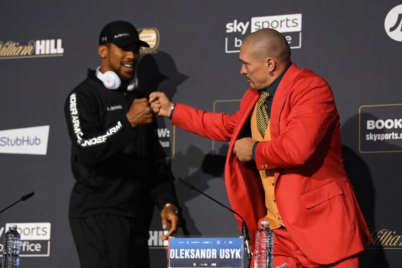 Anthony Joshua, left, and Oleksandr Usyk bump fists during a press conference ahead of their world heavyweight title fight at Tottenham Hotspur Stadium in London on Saturday, September 25. Getty