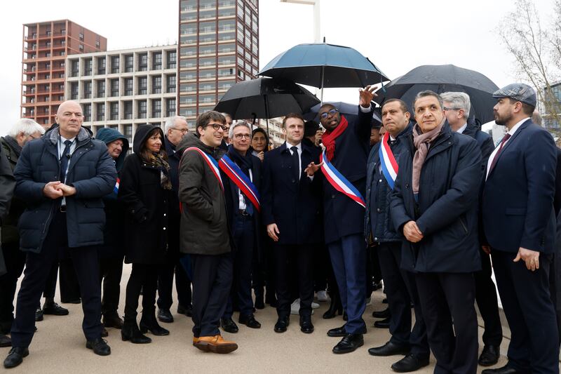 France's President Emmanuel Macron, surrounded by officials, attends the inauguration ceremony of the Paris 2024 Olympic village in Saint-Denis, north of Paris. AP