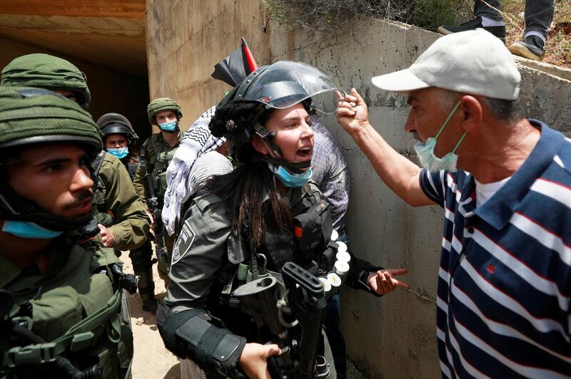 A Palestinian man argues with an Israeli border policewoman during a protest marking the 72nd anniversary of Nakba and against Israeli plan to annex parts of the occupied West Bank, in the village of Sawiya near Nablus on May 15, 2020. Reuters