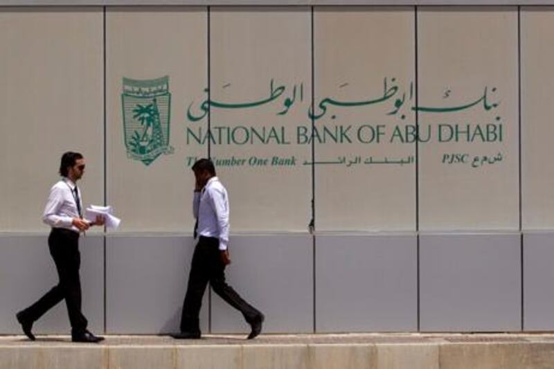 Abu Dhabi, United Arab Emirates, July 31, 2012:    Men outside the National Bank of Abu Dhabi NBAD branch at the intersection of Murrour and 15th streets in Abu Dhabi on July 31, 2012. Christopher Pike / The National
