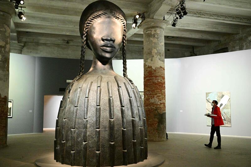 A visitor views "Brick House", a 2019 bronze sculpture by artist Simone Leigh, during a press day at the 59th Venice Art Biennale in Venice on April 19, 2022.  (Photo by Vincenzo PINTO  /  AFP)  /  RESTRICTED TO EDITORIAL USE - MANDATORY MENTION OF THE ARTIST UPON PUBLICATION - TO ILLUSTRATE THE EVENT AS SPECIFIED IN THE CAPTION