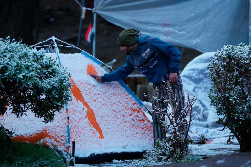 A Iraqi demonstrator wipes the snow off his tent in Tahrir Square. AP Photo