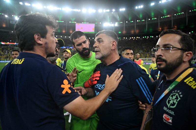 Brazil coach Fernando Diniz talks with Argentina's physiotherapist Marcelo D'Andrea after clashes erupted in the stands. AFP