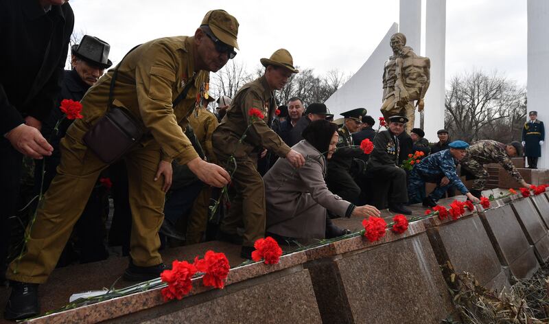 People lay flowers at a memorial monument to Soviet soldiers killed while fighting Afghan rebels in the 1980s, during a ceremony in Bishkek. AFP