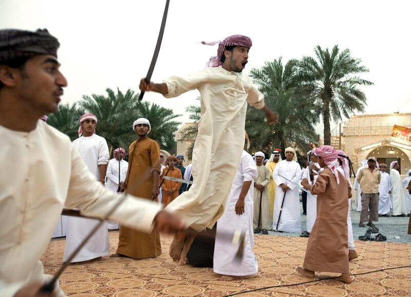 al Rams- April 17, 2009 - A young boy leaps into the air with his sword or Saif (CHECK SPELLING) during a mock battle with another boy during a traditional Arabic dance called the Razif at an Emirati wedding celebration for two grooms of the Shehhi tribe in the village of al Mahboobi in al Rams near Ras al Khaimah April 17, 2009.  The blades have been dulled to help prevent serious injury if one makes contact with the blade. (Photo by Jeff Topping/The National) *** Local Caption ***  JT002-0417-EMIRATI WEDDING IMG_6836.JPG