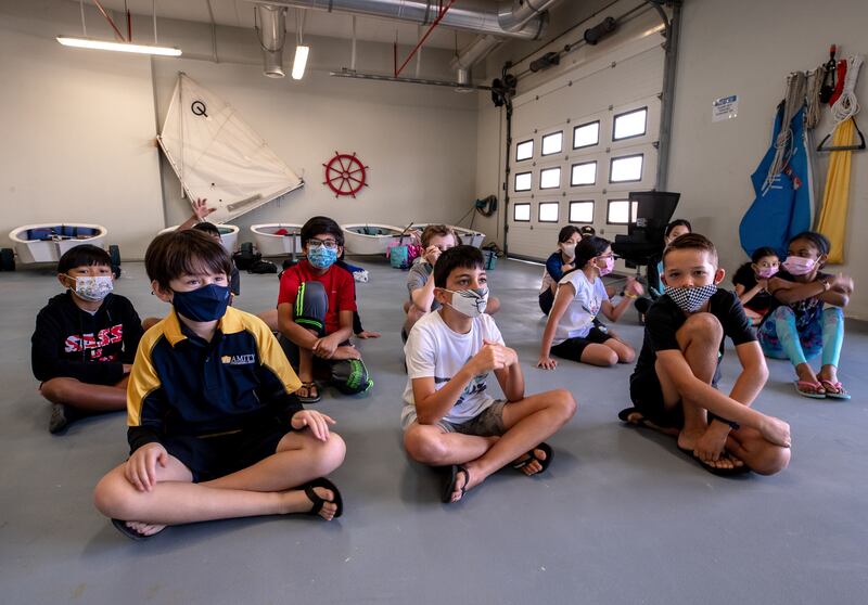 Amity children take part in a safety briefing before heading out for a morning of sailing.