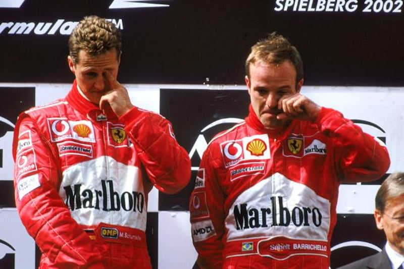A1 RING - MAY 12:  Race winner Ferrari driver Michael Schumacher of Germany and runner-up Ferrari driver Rubens Barrichello of Brazil stand on the podium after the Austrian Formula One Grand Prix held at the A1 Ring in Spielberg, Austria on May 12, 2002. They swapped places on the podium as Barrichello led most of the race but under team orders let Schumacher overtake him on the last lap to win the race. (Photo by Tom Shaw/Getty Images)