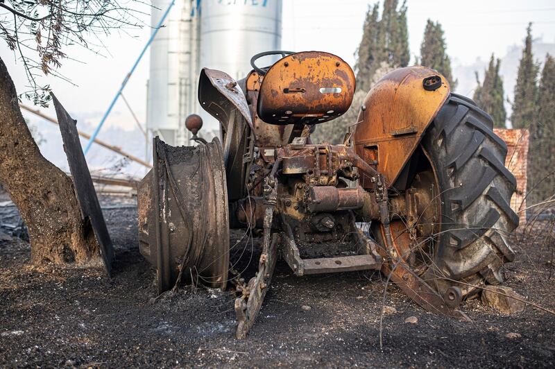 A burned farm tractor lays destroyed after a wildfire swept through Torre de l'Espanyol. AP Photo
