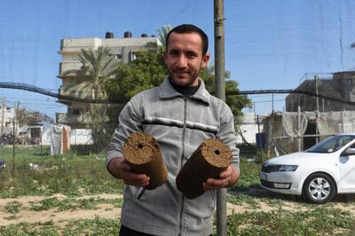 Mohammad El Gha, 31, holds two olive peel blocks in Khan Yunis, southern Gaza. Rosie Scammell for The National