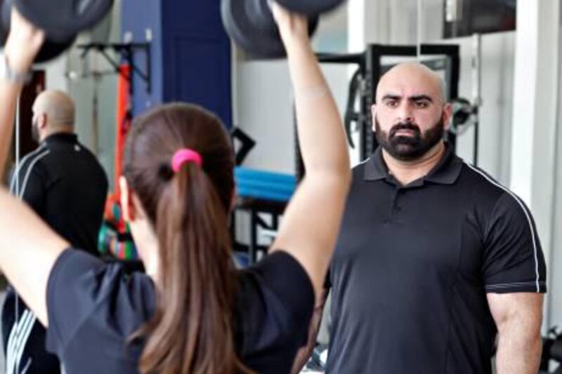 DUBAI, UNITED ARAB EMIRATES - July 24, 2012 - Personal trainer Amir Siddiqui watches while Amina Nasim Jan goes through her training session at Symmetry Gym in Dubai City, Dubai July 24, 2012. (Photo by Jeff Topping/The National) 