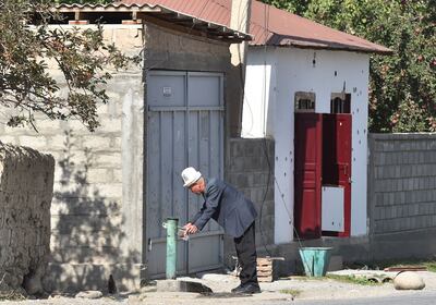 A man collects water near a damaged house in the village of Ak-Say near the Kyrgyz-Tajik border, some 1000 kilometres from Bishkek, on September 20. AFP
