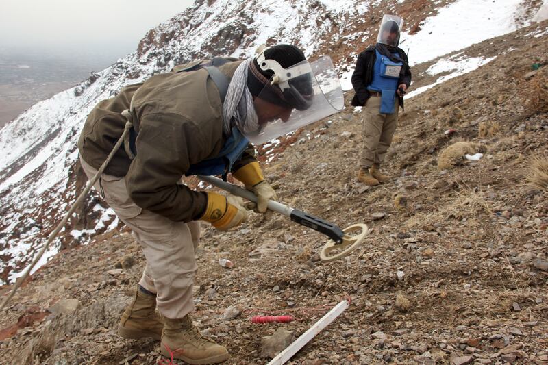 A minesweeper from Halo works meticulously with a metal detector along a mountainside contaminated with IEDs in Parwan Province, Afghanistan. Getty Images