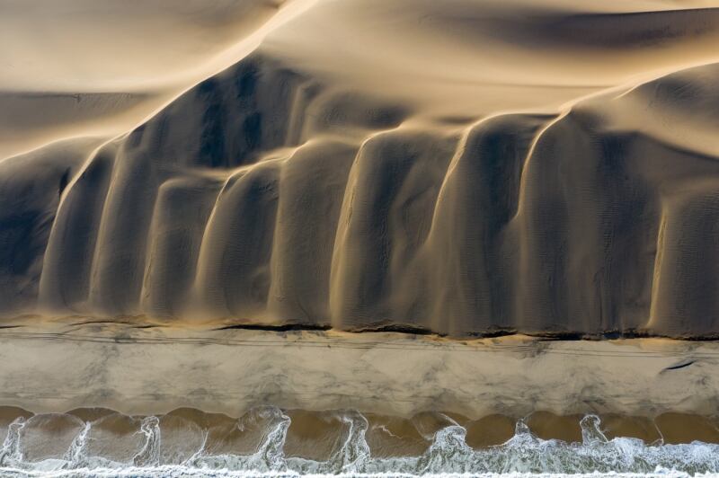 An evocative encounter between the desert dunes and the South Atlantic Ocean, photographed by Swiss photographer David Rouge, won first place in the Nature category.
