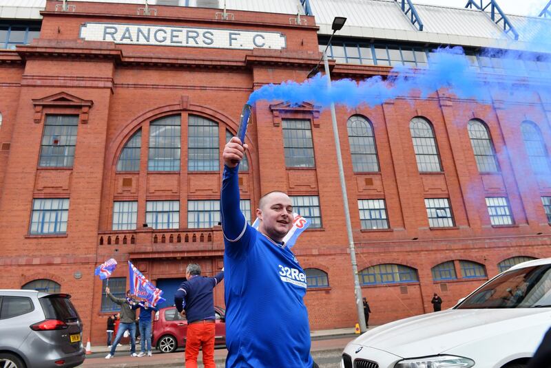 Fans celebrate with smoke bombs after Rangers won the Scottish Premiership title for the first time in a decade.