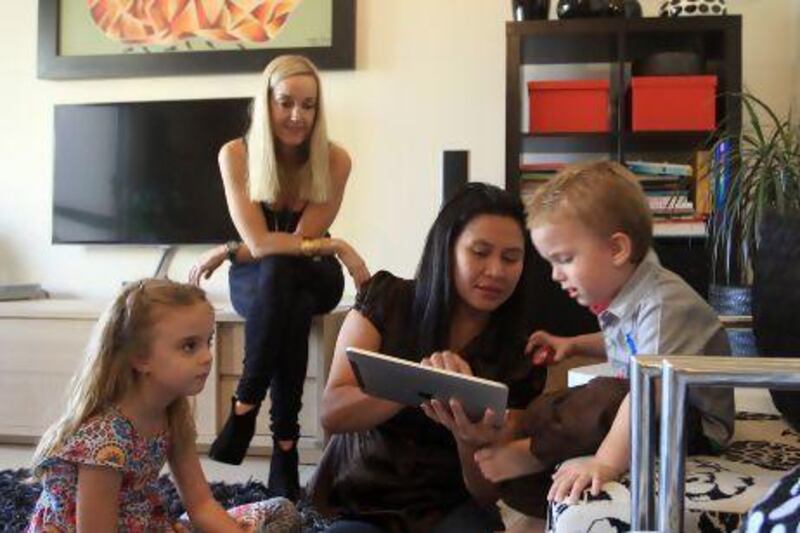 Leny Alzaga, centre, a Filipina housemaid, with her employers Joanna Robinson, second left, and children Summer and Chase Robinson, inside their home at Jumeirah Beach Residence in Dubai.