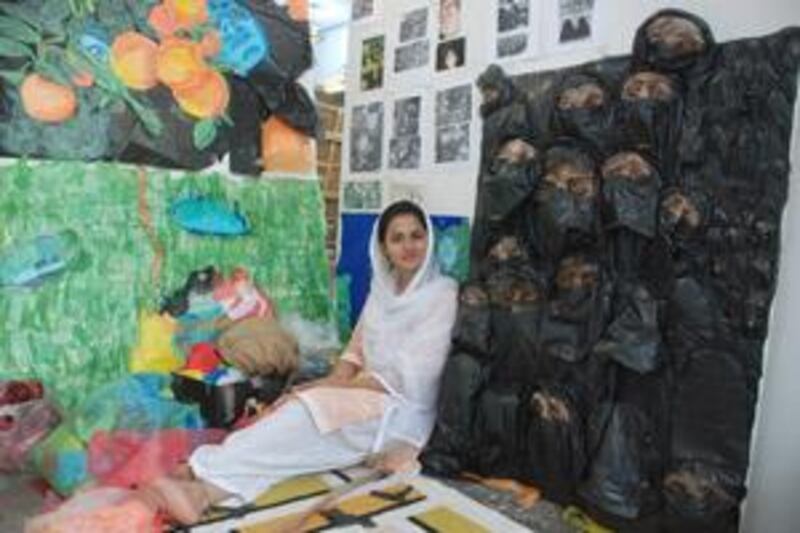 Karren Jamir sits next to her sculpture, Suffocation, which she says was inspired by decrees issued when the Taliban ruled Afghanistan in the 1990s.