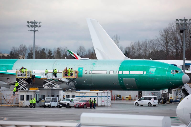 Boeing workers are pictured near a 777X airplane during a first flight event, which had to be rescheduled due to weather, at Paine Field in Everett, Washington on January 24, 2020. AFP