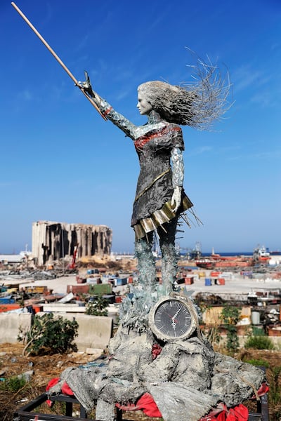 A statue of a woman by Lebanese artist Hayat Nazer, made out of leftover glass, rubble, and a broken clock marking the time (6:08 PM) of the mega explosion at the port of Beirut is placed opposite to the site of the blast in the Lebanese capital's harbour, to mark the one year anniversary of the beginning of the anti-government protest movement across the country, on October 20, 2020. - Hundreds marched in Beirut on the weekend to mark the first anniversary of a non-sectarian protest movement that has rocked the political elite but has yet to achieve its goal of sweeping reform. A whirlwind of hope and despair has gripped the country in the year since protests began, as an economic crisis and a devastating port explosion two months ago pushed Lebanon deeper into decay. (Photo by JOSEPH EID / AFP) / RESTRICTED TO EDITORIAL USE - MANDATORY MENTION OF THE ARTIST UPON PUBLICATION - TO ILLUSTRATE THE EVENT AS SPECIFIED IN THE CAPTION