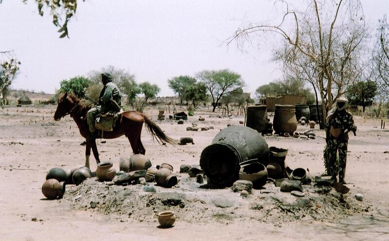 Picture taken in April 2004 shows the village of Khair Wajid after being burnt by the pro-Sudanese government "Janjaweed" militias in the western Darfur region of Sudan. Fighting in Darfur that has erupted in February 2003 between the Sudanese government and Darfur rebels has claimed at least 10,000 lives and raised the spectre of a devastating humanitarian crisis that could see up to one million die, the UN and international officials have said. The Arab "Janjaweed" militia have been accused of ethnic cleansing against the black population of the Darfur region.            AFP PHOTO/Julie FLINT (Photo by JULIE FLINT / AFP)